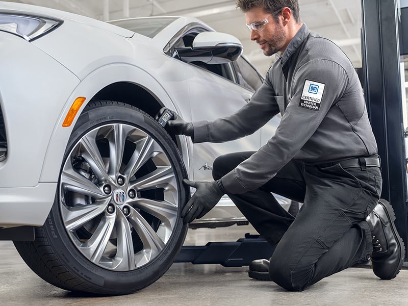 Close-up View of a GM Certified Service Master Technician Checking the Tread on a Buick SUV’s Tire