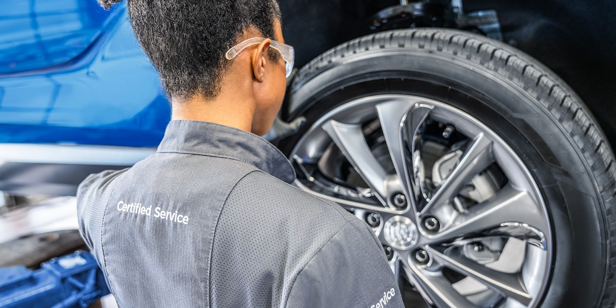 Buick Certified Service Representative Inspecting a Vehicle's Tire