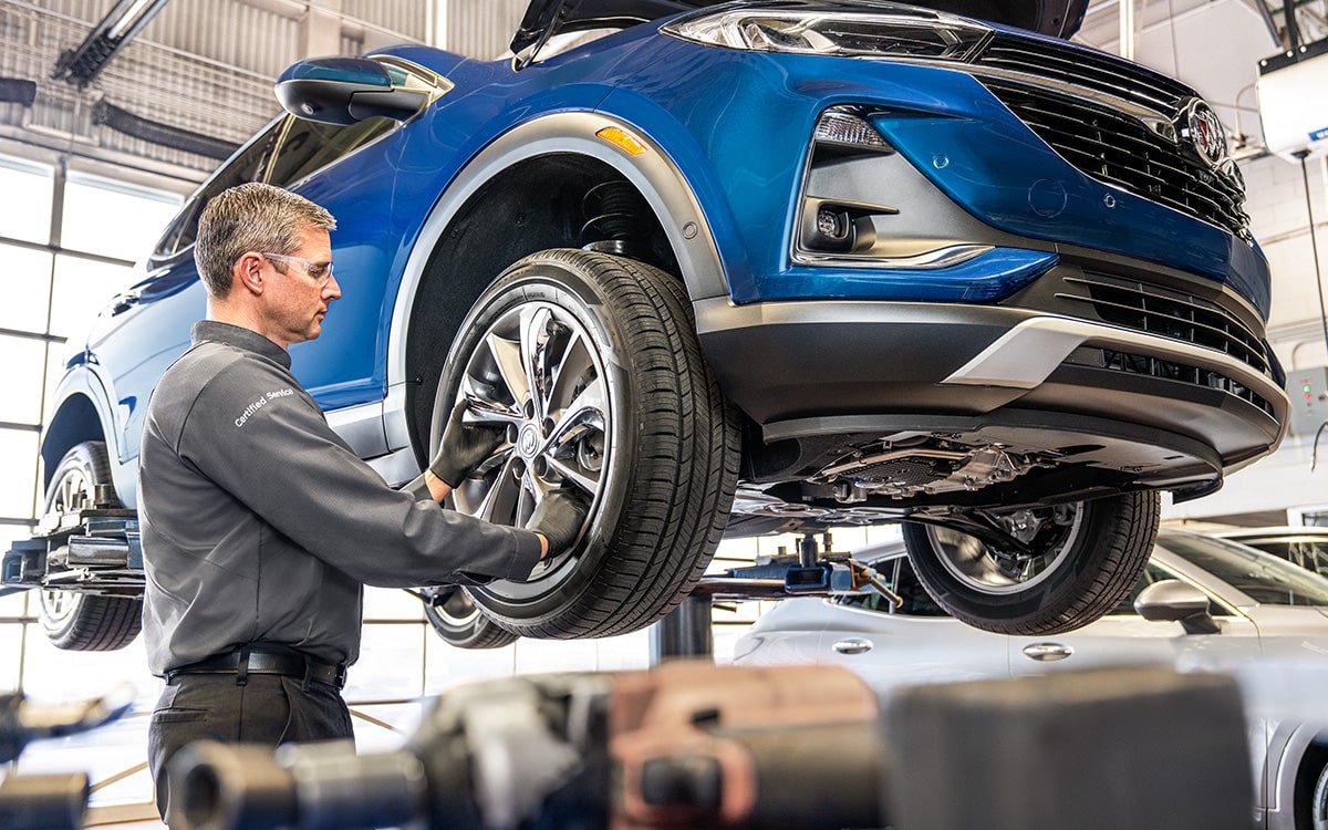 Buick Certified Service Representative Inspecting a Vehicle's Tire