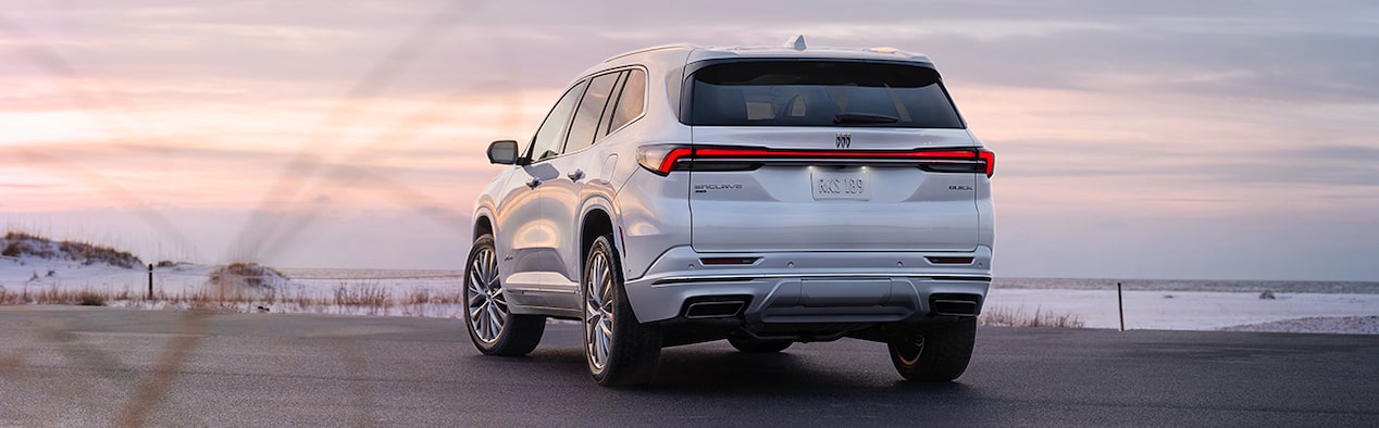 White Buick SUV Parked on a Road Pointed Towards a Body of Water